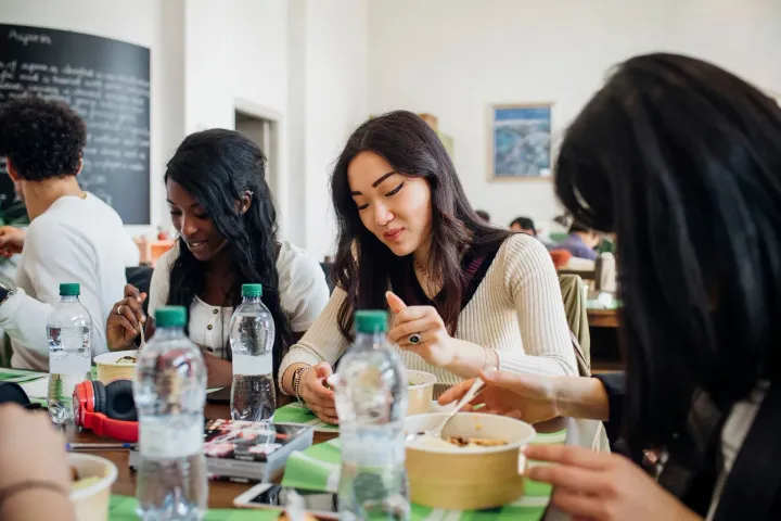 Guests sharing feedback on their phones over a meal.