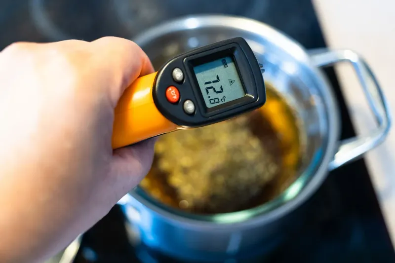 A thermometer reading the temperature of food in a pot during a food safety check.